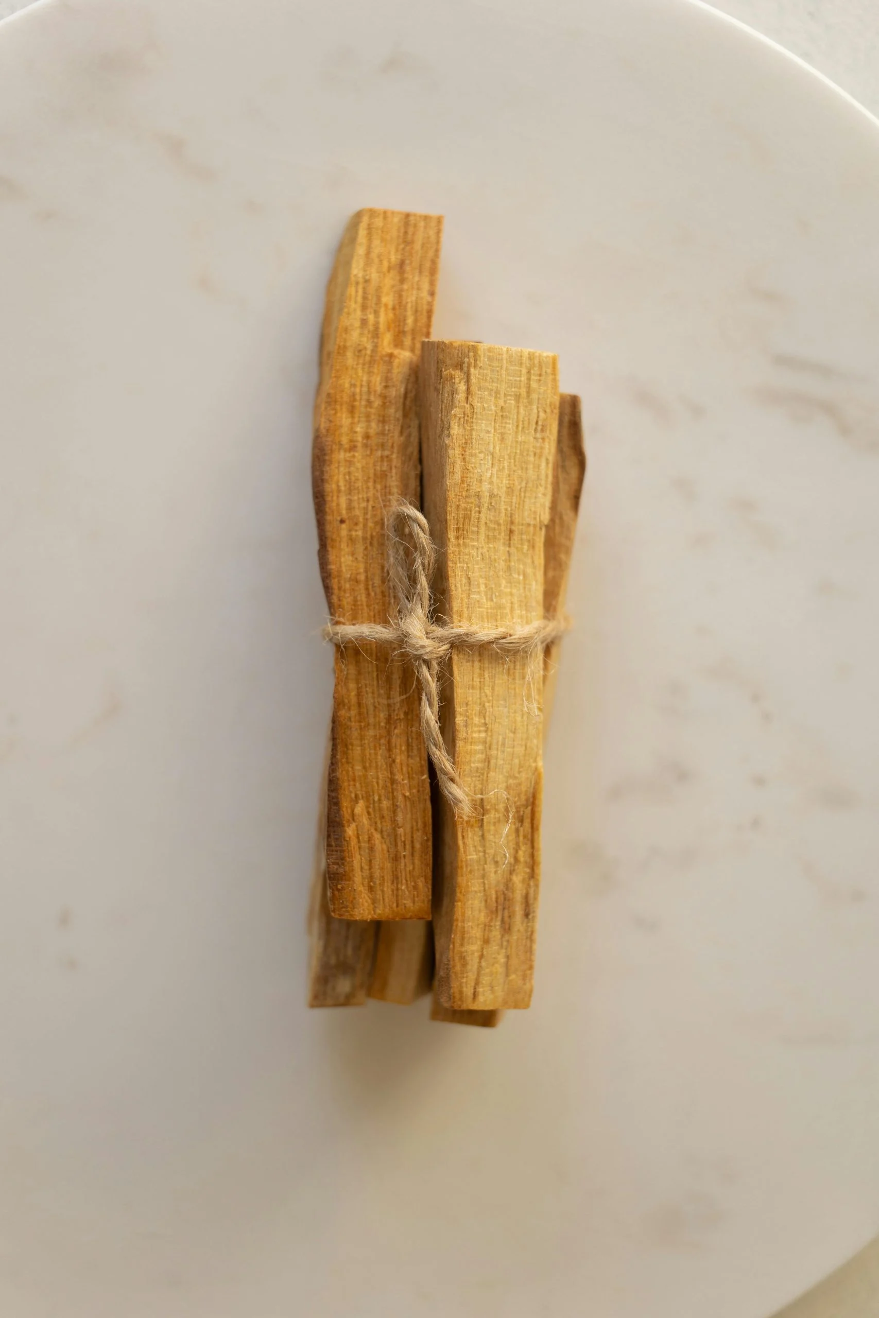 Beyaz zeminde iple bağlanmış iki Palo Santo çubuğu