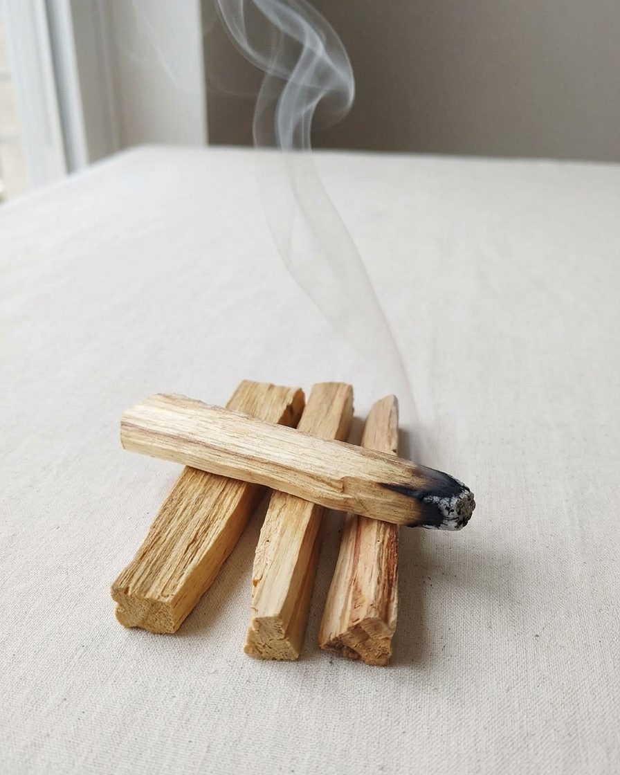 Keten üzerinde Palo Santo çubukları; birinin ucundan ince bir duman yükseliyor